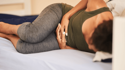 A women laying in bed in pain with endometriosis